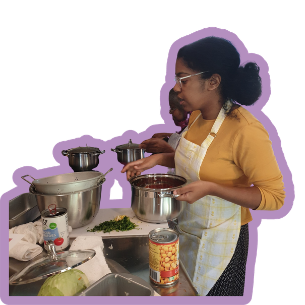 A cook working at large pots in the Field & Kitchen shared kitchen