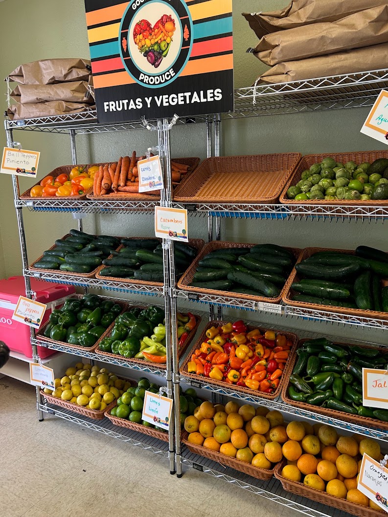 Free market shelves stocked with fresh produce and bilingual signs
